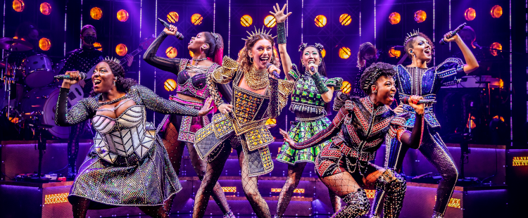 a photograph of the cast of Six the musical performing on stage