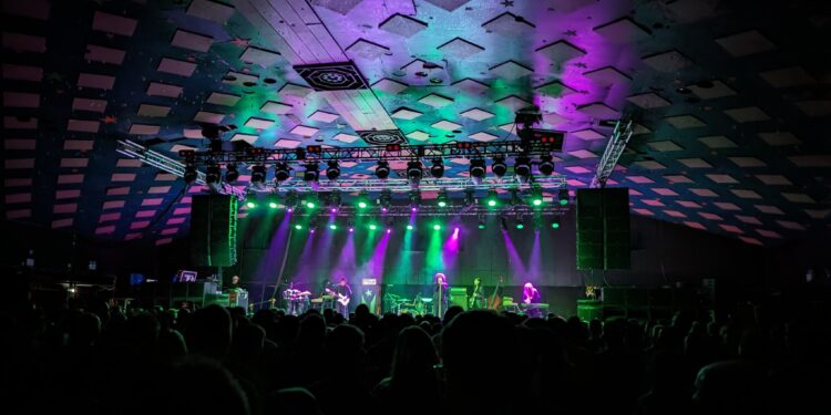 A photo of The Mars Volta on stage at Barrowlands. The stage is lit up with purple and green spotlights