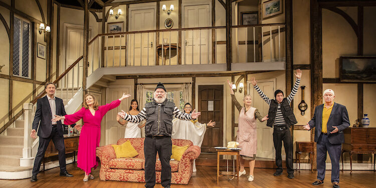 The cast of noises off stand on set