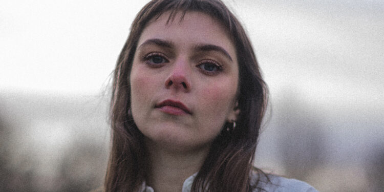 Jodie Nicholson is looking in to the camera she has shoulder length brown hair
