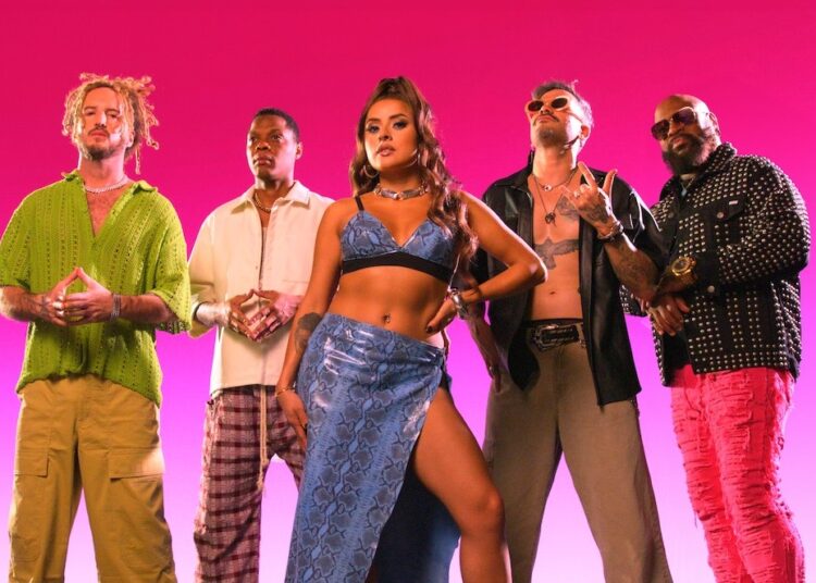 The band stand in front of a pink background