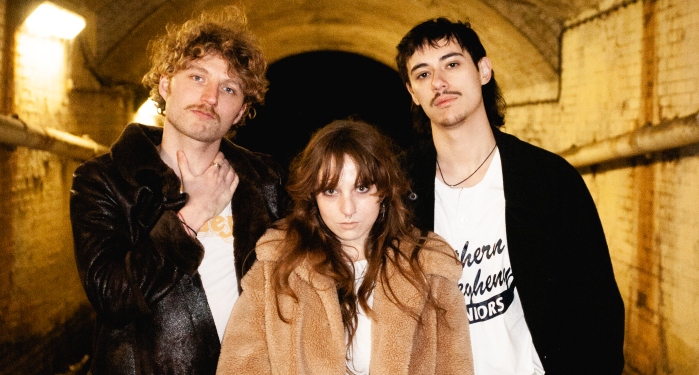 Three cool musicians stand in a tunnel