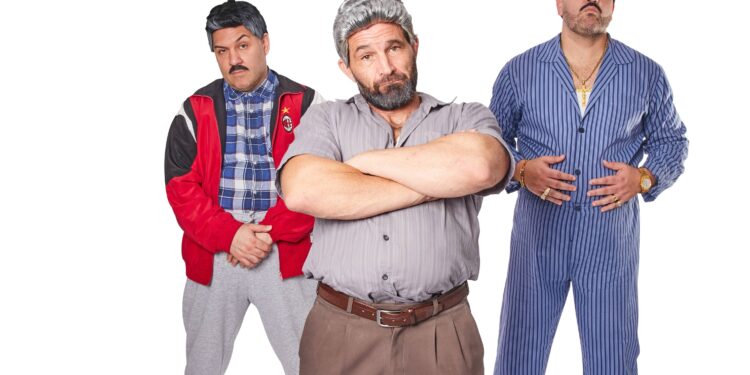 Three men in character costumes pose together against a plain white background.