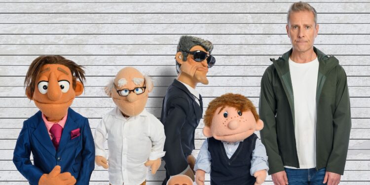 Man standing beside five ventriloquist puppets posed against a lined backdrop